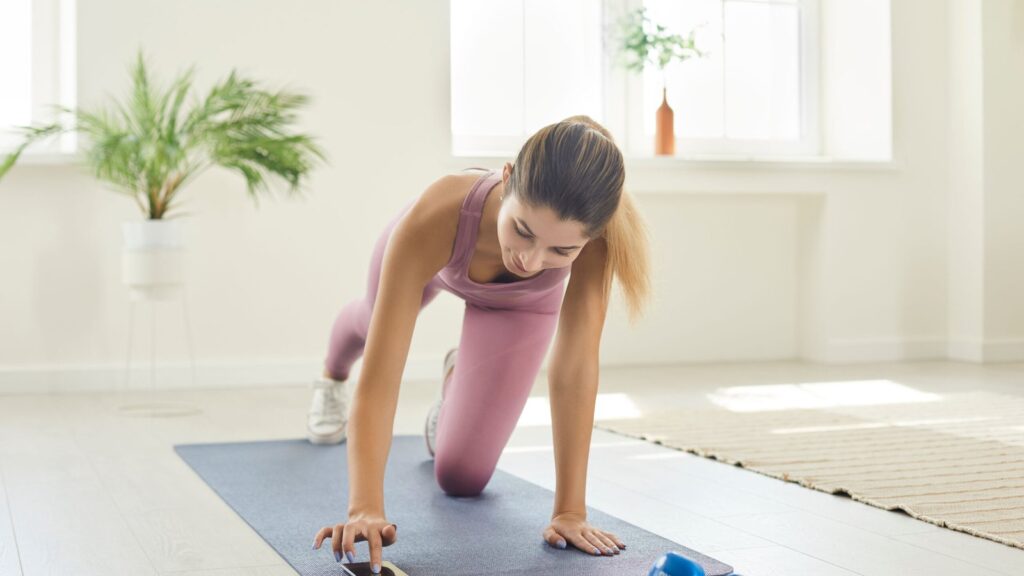 Woman in pink athletic wear performing indoor floor exercise on yoga mat as part of fascia relief routine