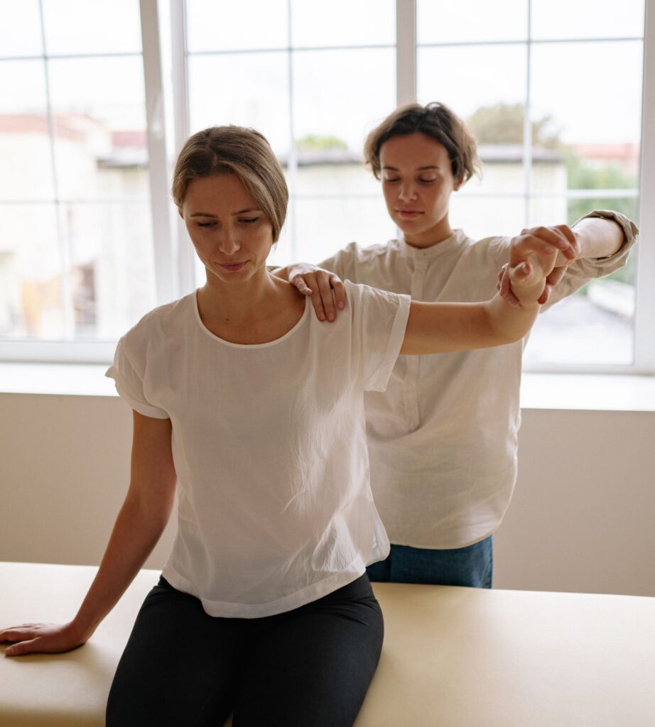 Therapist performing guided fascia therapy on patient’s shoulder in clinic setting to improve mobility and relieve stiffness