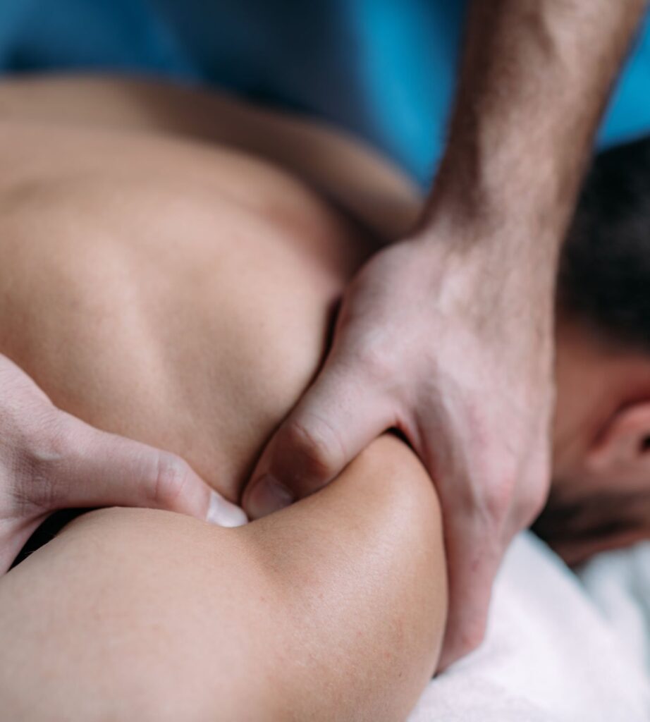 Close-up of physical therapist applying fascia release technique to a patient's back, guided by the TheraFascia app for targeted mobility improvement